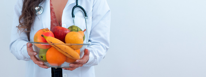 Female doctor holding fruit basket
