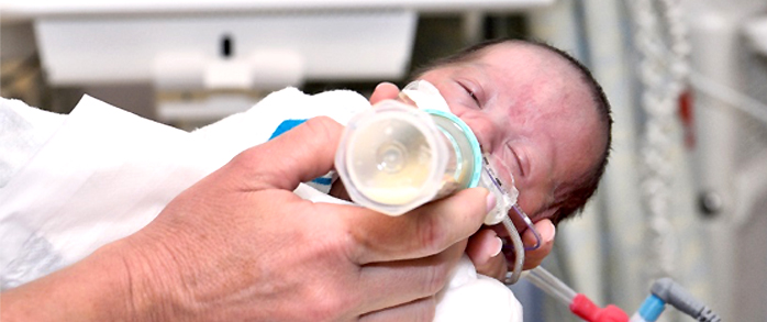 A newborn being fed breast milk.