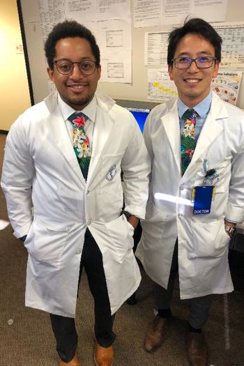 Two doctors wearing Hawaiian ties with their lab coats.