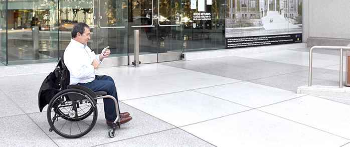 man in a wheelchair looking at his phone
