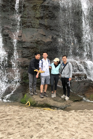 Group hiking under a waterfall