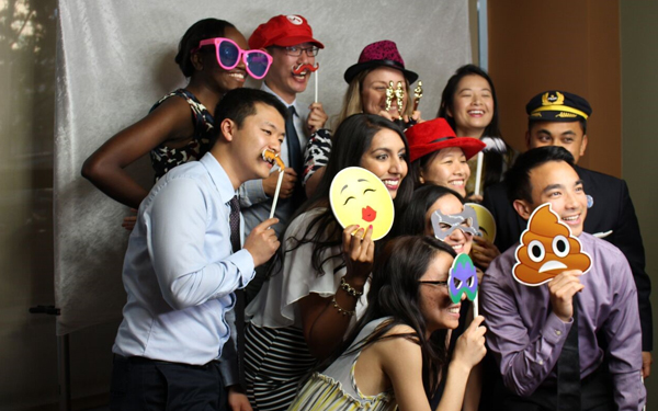 Students at a graduation photo booth with props.