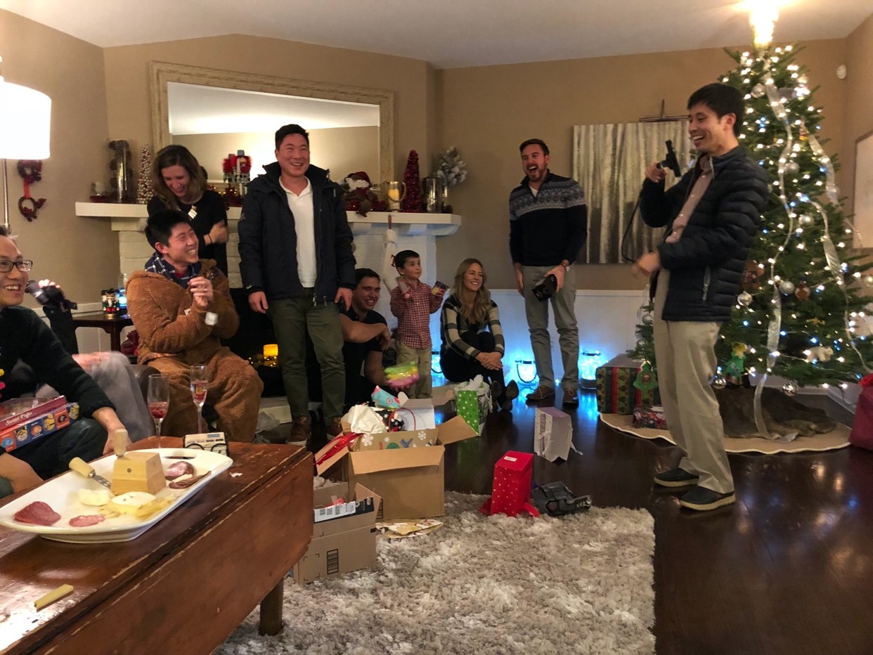 group of people standing and laughing in the living room